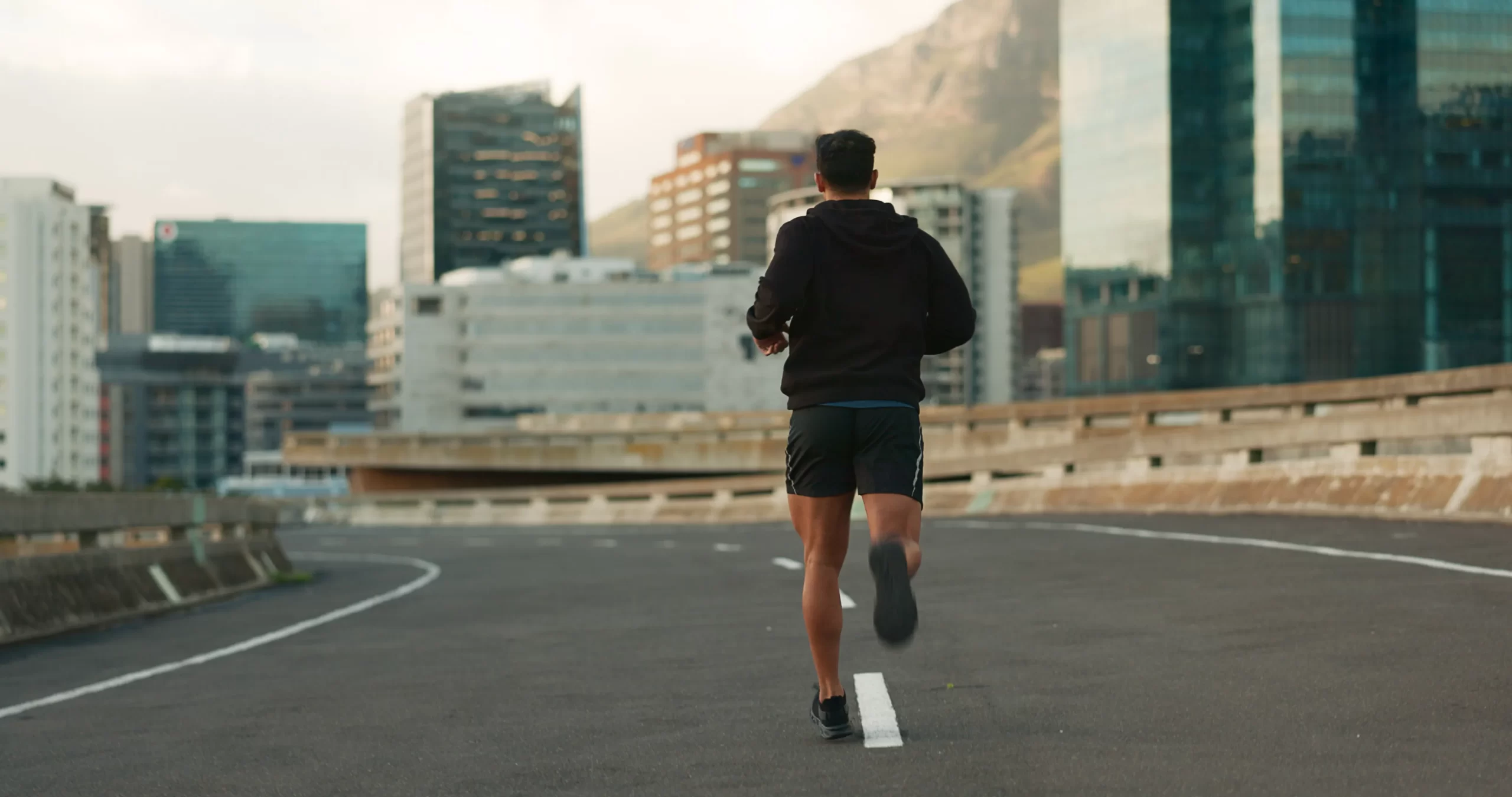 man runs on overpass during daytime cityscape utc
